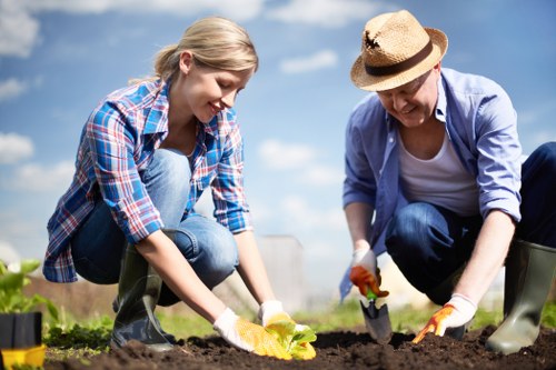 Close-up of hands tending to plants illustrating practical Teddington gardening work.