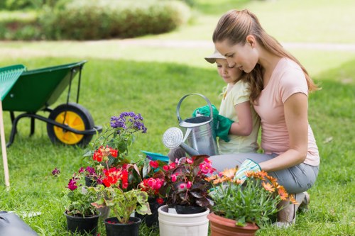 Gardener wearing PPE while pruning a shrub