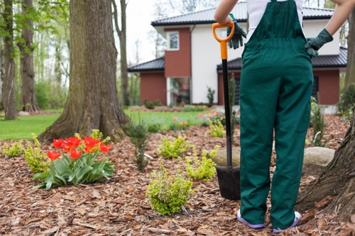 Operatives wearing PPE and using ground protection boards in a garden